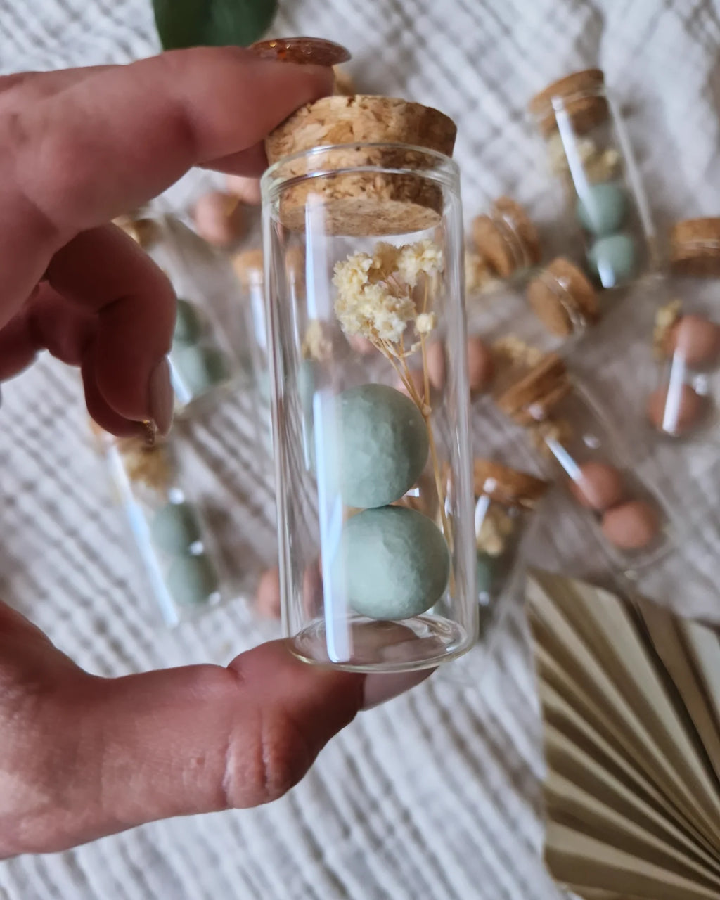 Groene blossombs in glazen buisje met droogbloemetje