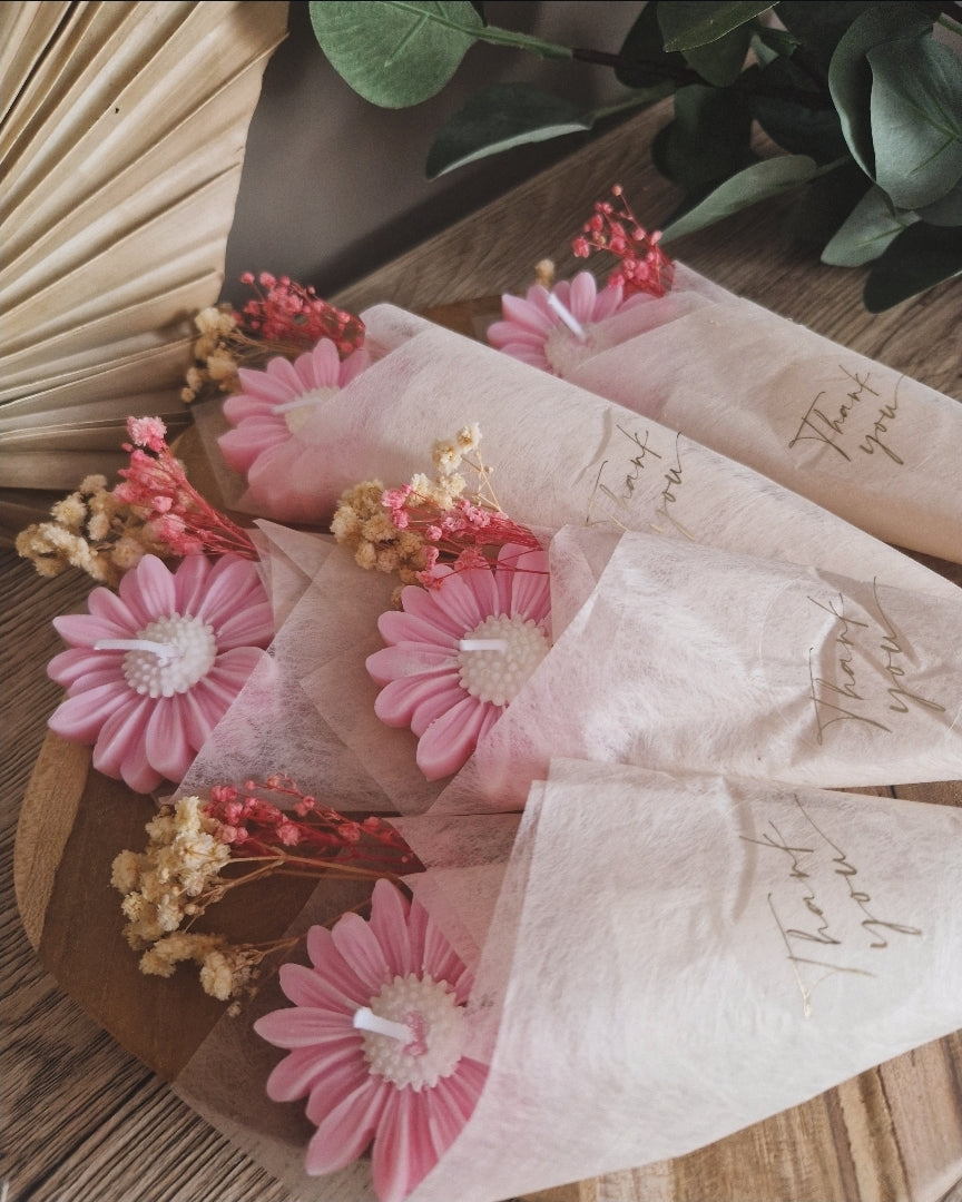 Miniboeketje met roze en witte madeliefkaarsjes in een beige zeidepapier met de sticker thank you